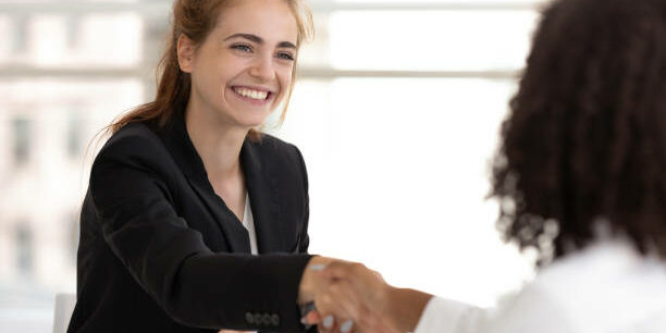 Happy businesswoman hr manager handshake hire candidate selling insurance services making good first impression, diverse broker and client customer shake hand at business office meeting job interview